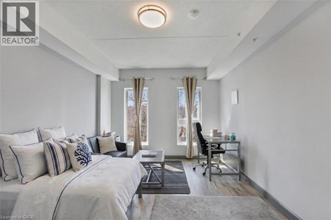 A bedroom with a large bed and a desk with a chair.