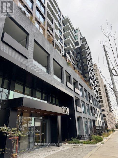 A modern building with a black facade and the number 1100 on the entrance.
