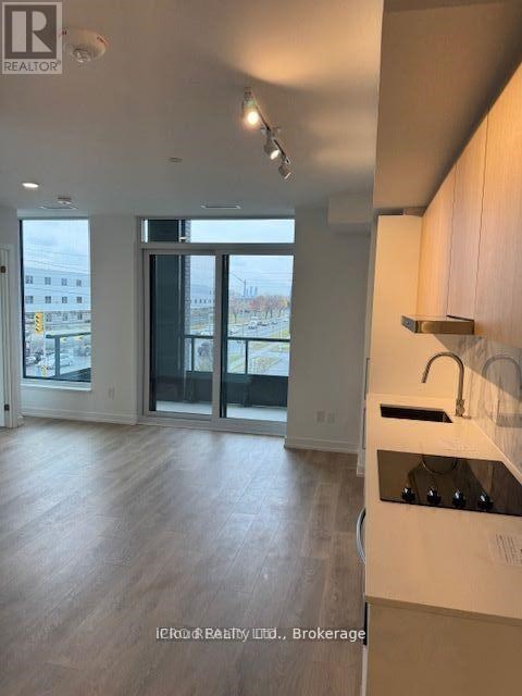 A kitchen with a sink and a window overlooking a parking lot.