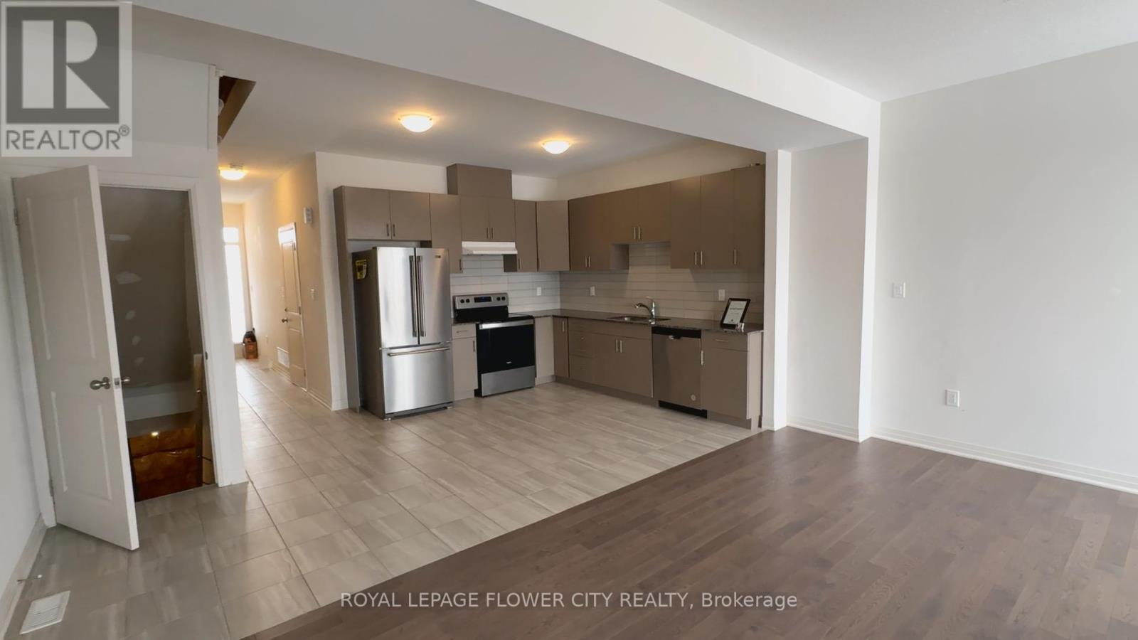 A spacious kitchen with a refrigerator, oven, and sink.