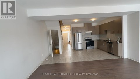 A spacious kitchen with stainless steel appliances and a dining area with a table and chairs.