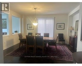 A dining room with a table and chairs.