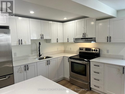 A kitchen with white cabinets and stainless steel appliances.