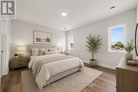 A bedroom with a large bed and a small tree in a pot.