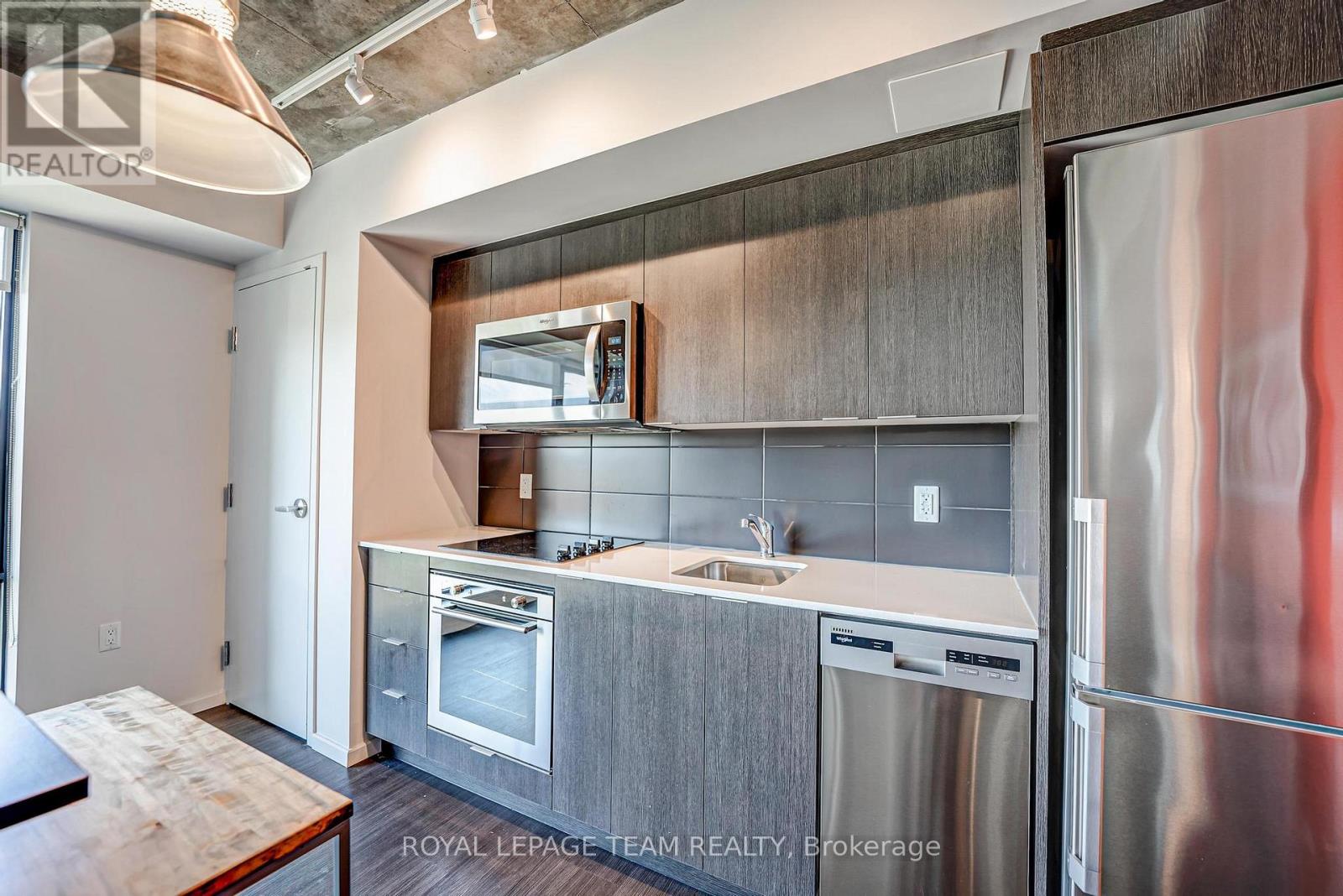 A modern kitchen with stainless steel appliances and wooden cabinets.