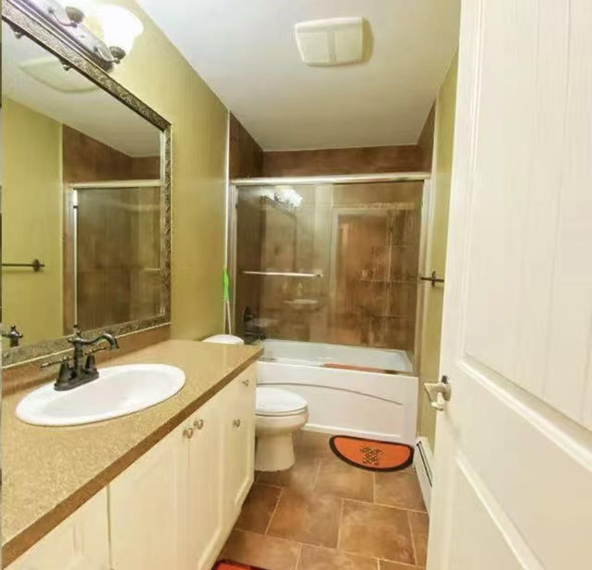 A bathroom with a sink, toilet, and shower.