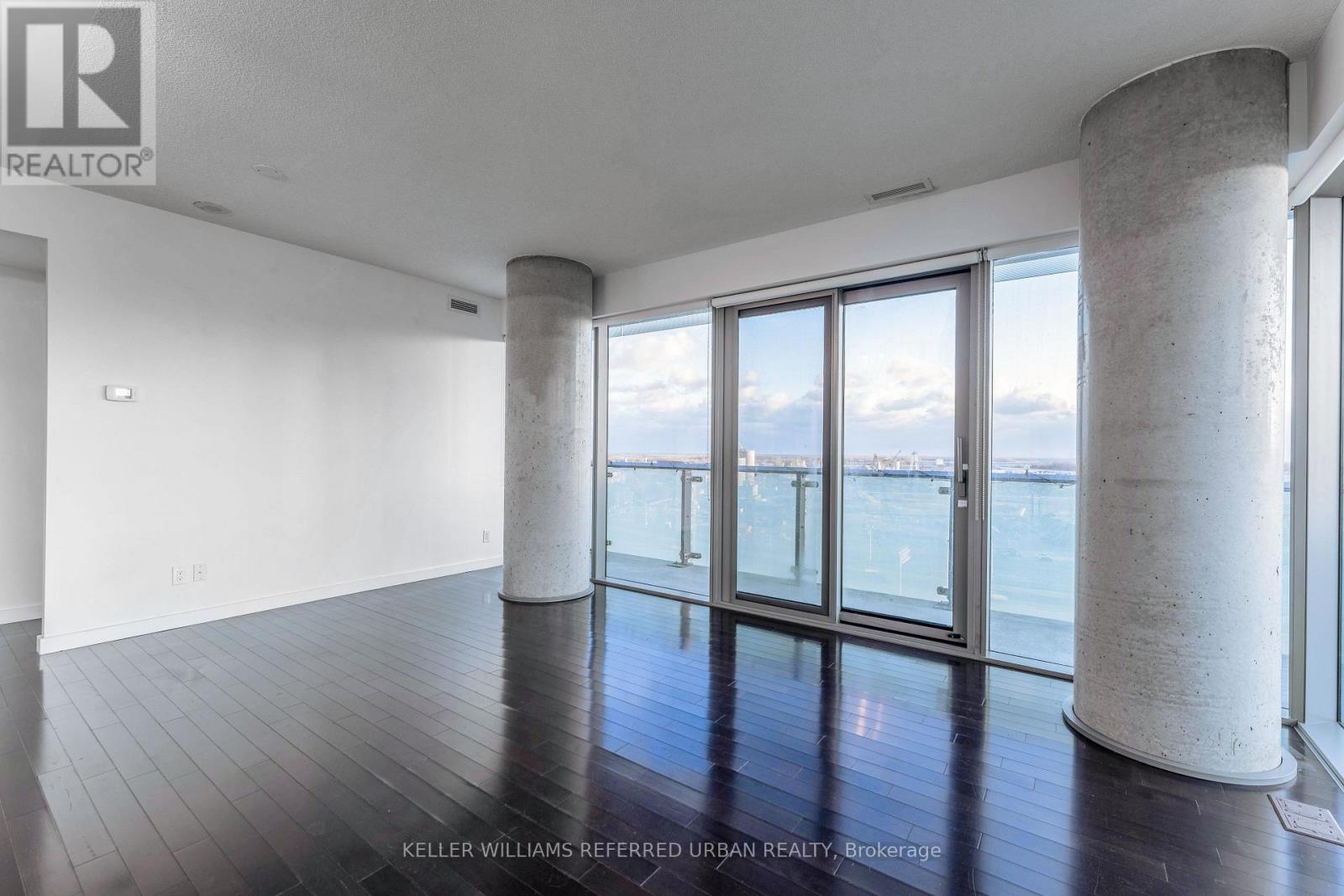 A spacious room with a view of the water through large windows.