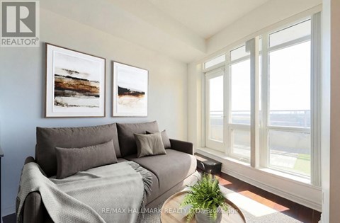 A living room with a grey couch and two framed pictures on the wall.