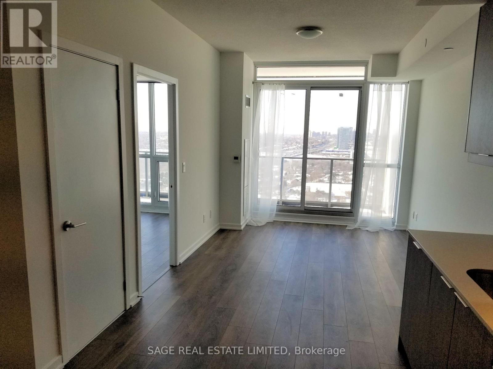 A spacious room with a view of the city through the windows.