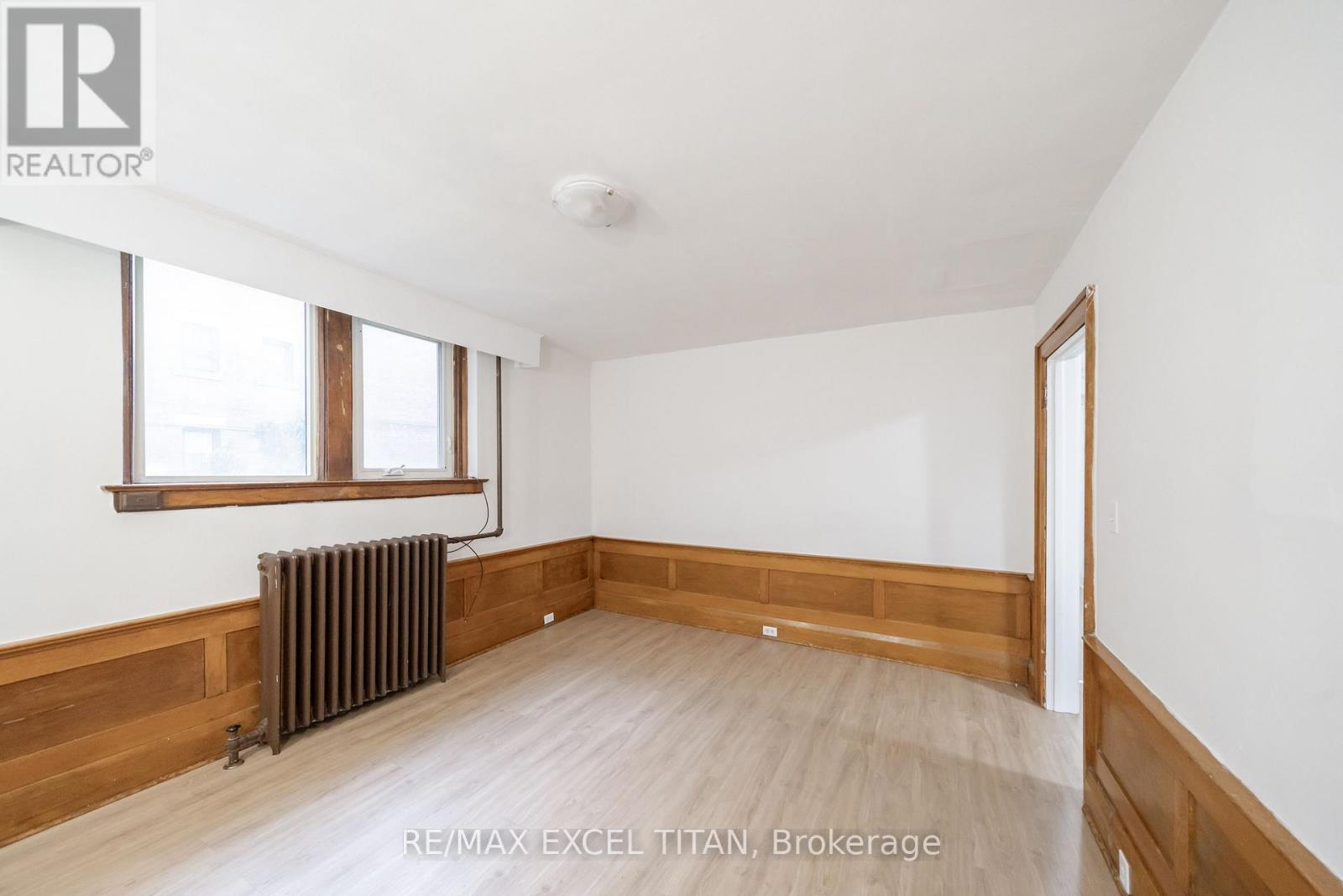 A room with a window and a radiator on the wall.
