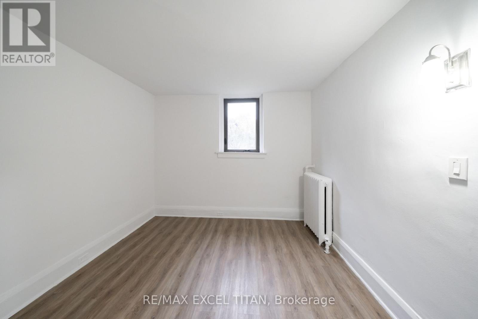 A room with a window and a radiator on the floor.