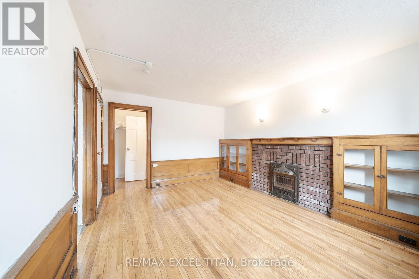 A room with a fireplace and wooden floors.