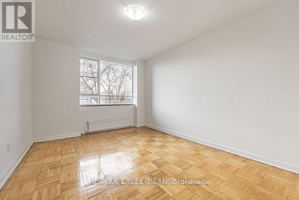 A room with wooden flooring and a window with a white frame.