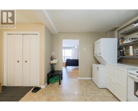 A kitchen area with a refrigerator, oven, and a dining table with chairs.