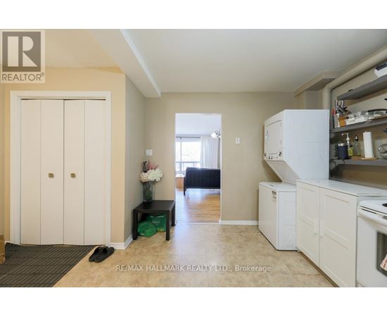 A kitchen area with a refrigerator, oven, and a dining table with chairs.