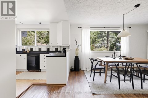 A modern kitchen with white cabinets and a black dishwasher.