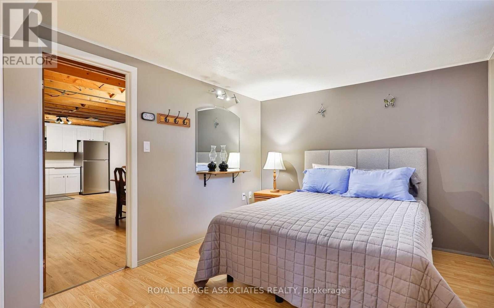 A bedroom with a bed, lamp, and a mirror on the wall.