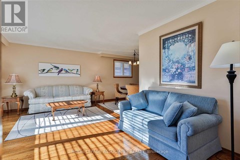 A living room with a blue couch and a painting on the wall.