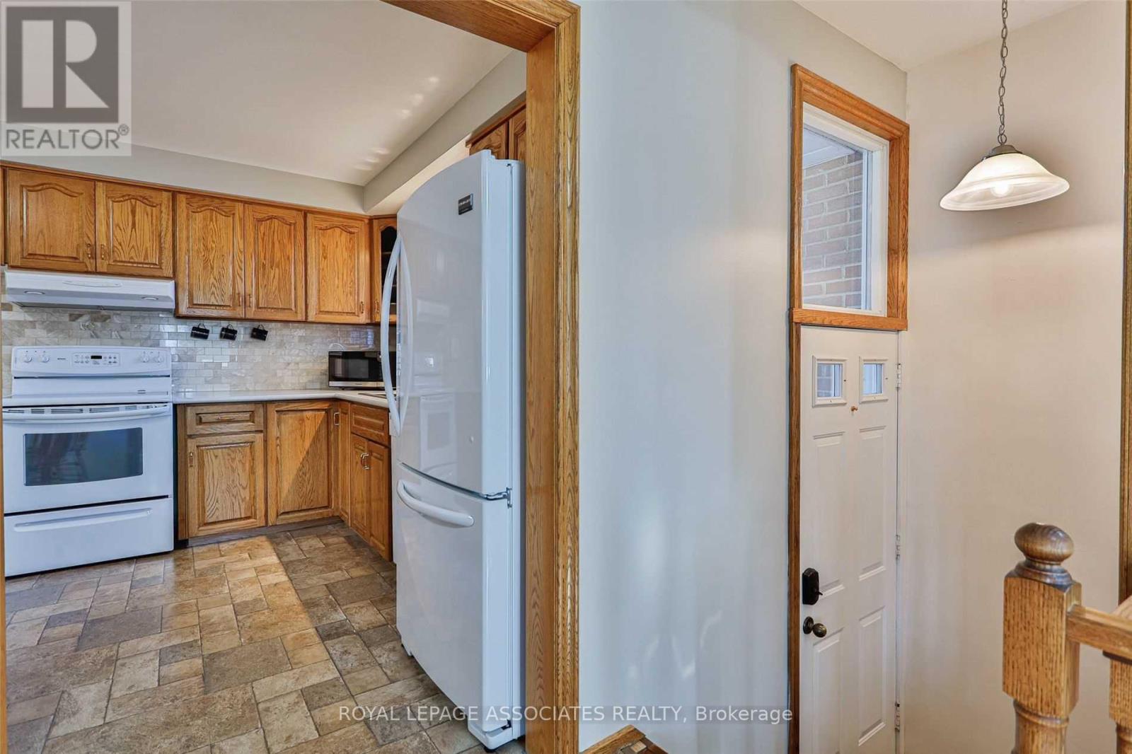 A kitchen with wooden cabinets and a white refrigerator.
