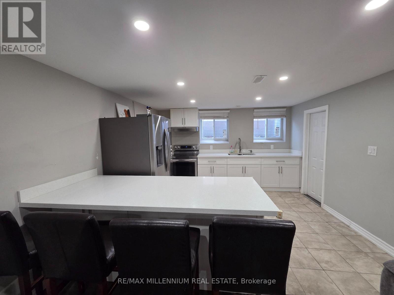 A dining area with a white table and black chairs.