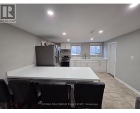 A dining area with a white table and black chairs.