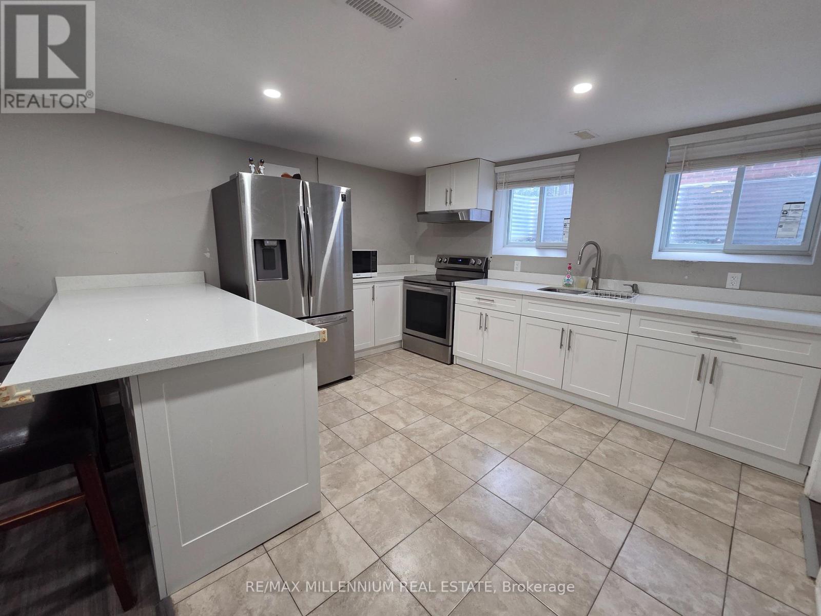 A kitchen with white cabinets and a tiled floor.