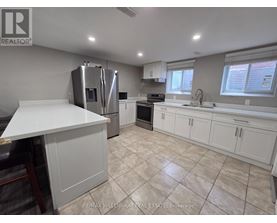 A kitchen with white cabinets and a tiled floor.