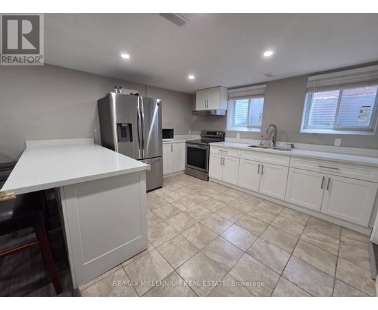 A kitchen with white cabinets and a tiled floor.
