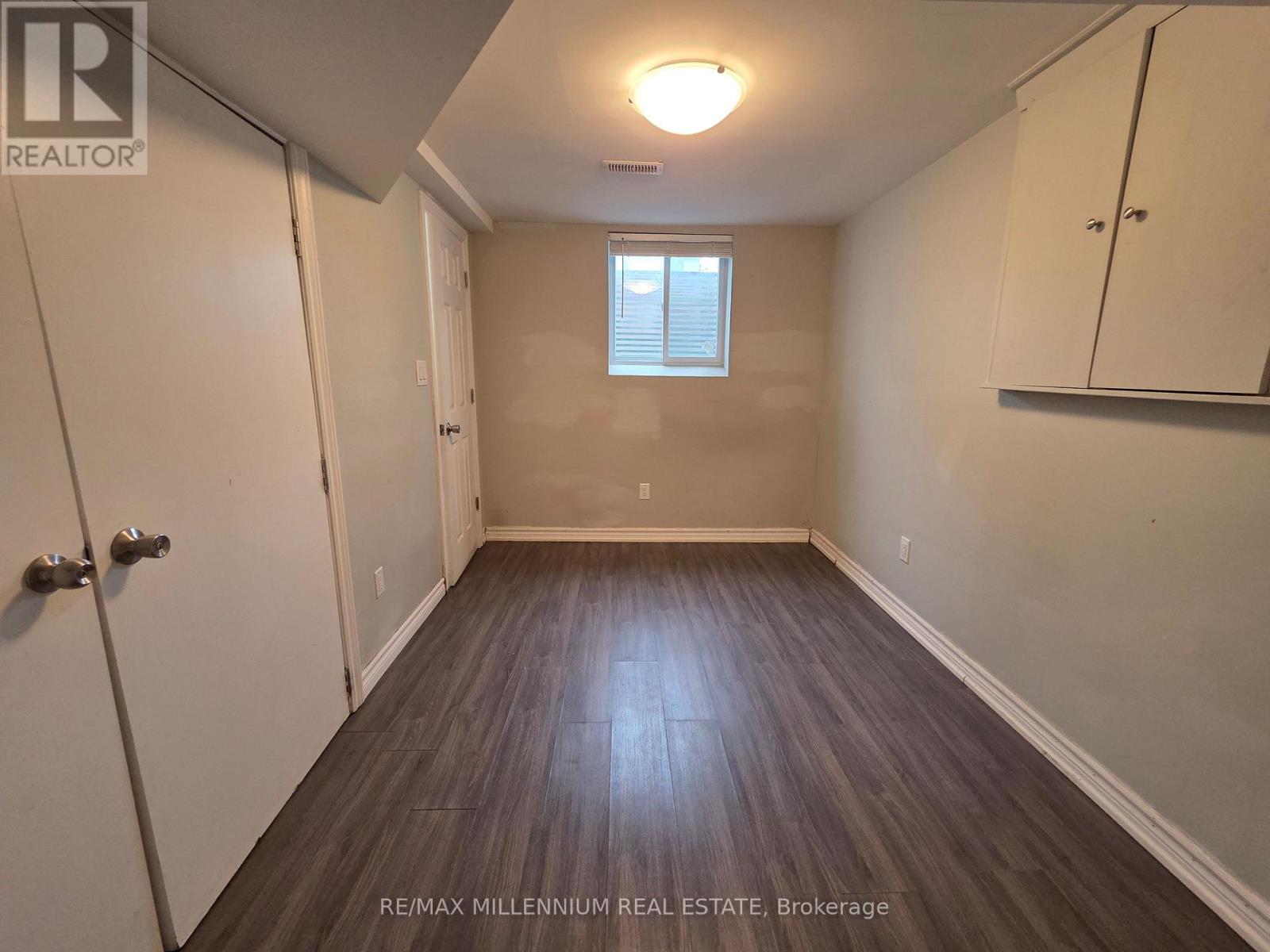 A room with wooden flooring and a window with blinds.