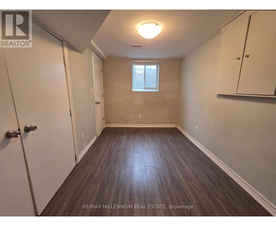 A room with wooden flooring and a window with blinds.