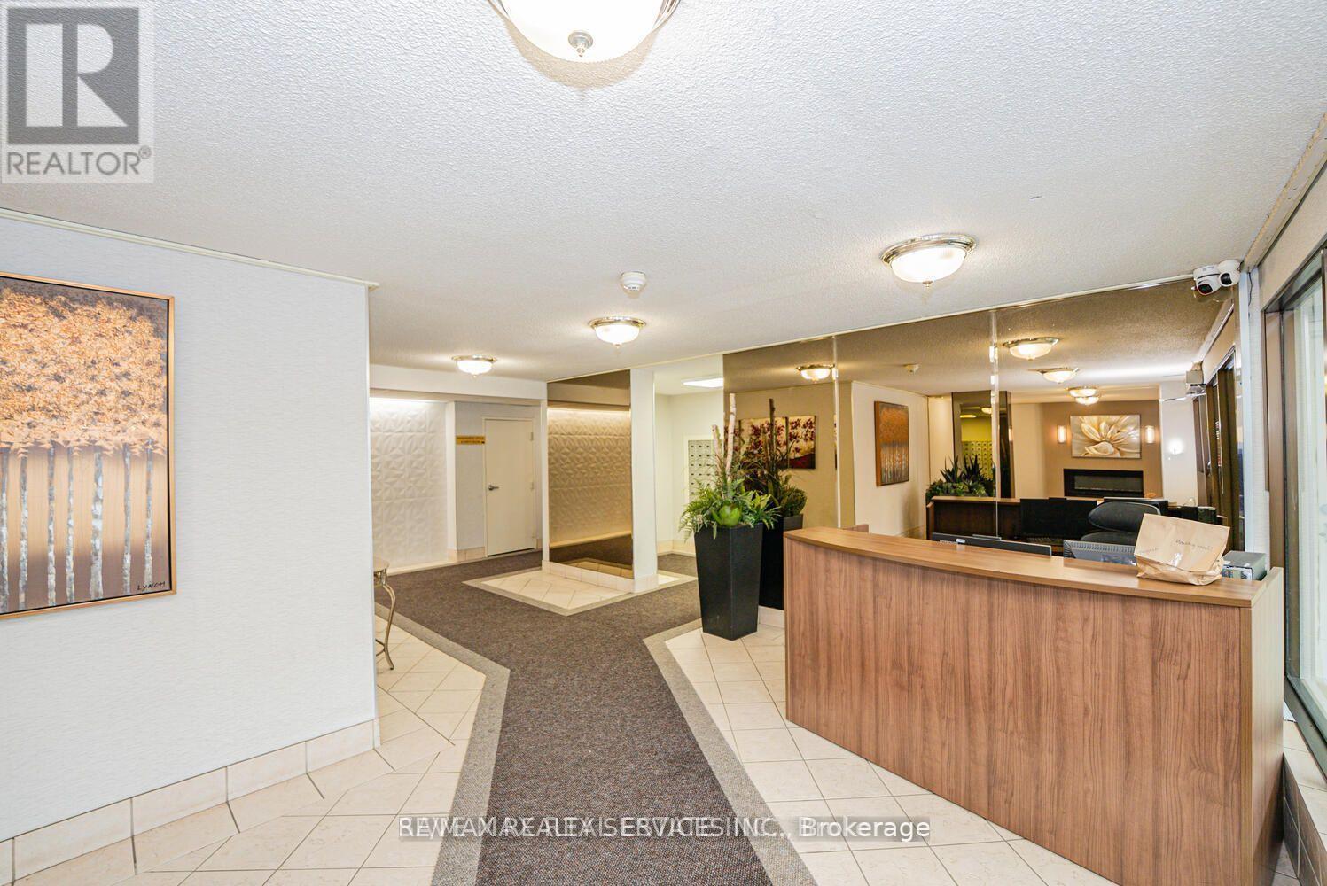 A reception area with a wooden desk and a large painting on the wall.