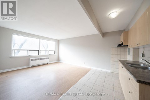 A spacious kitchen with wooden cabinets and a black countertop.