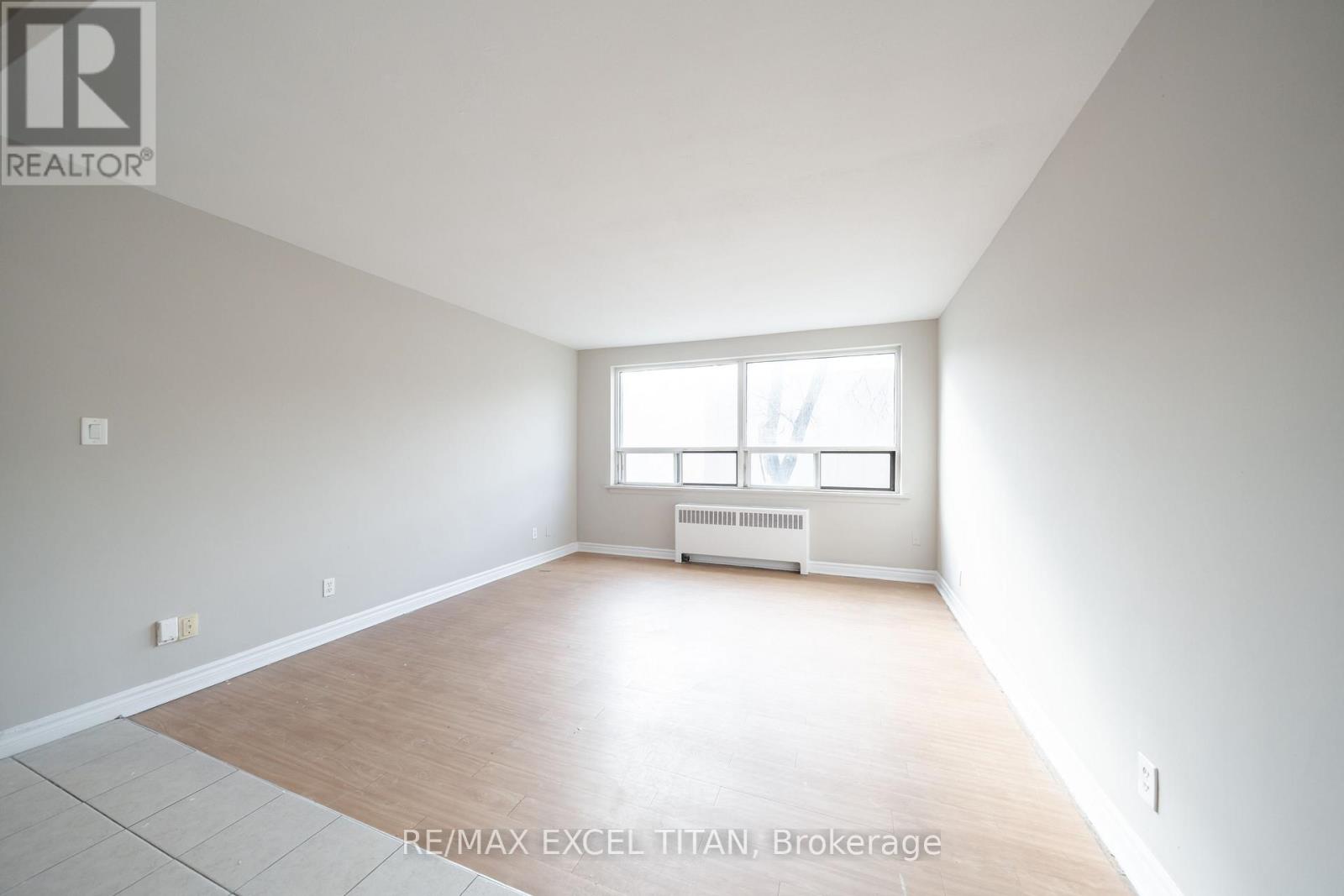 A spacious room with a window and radiator.