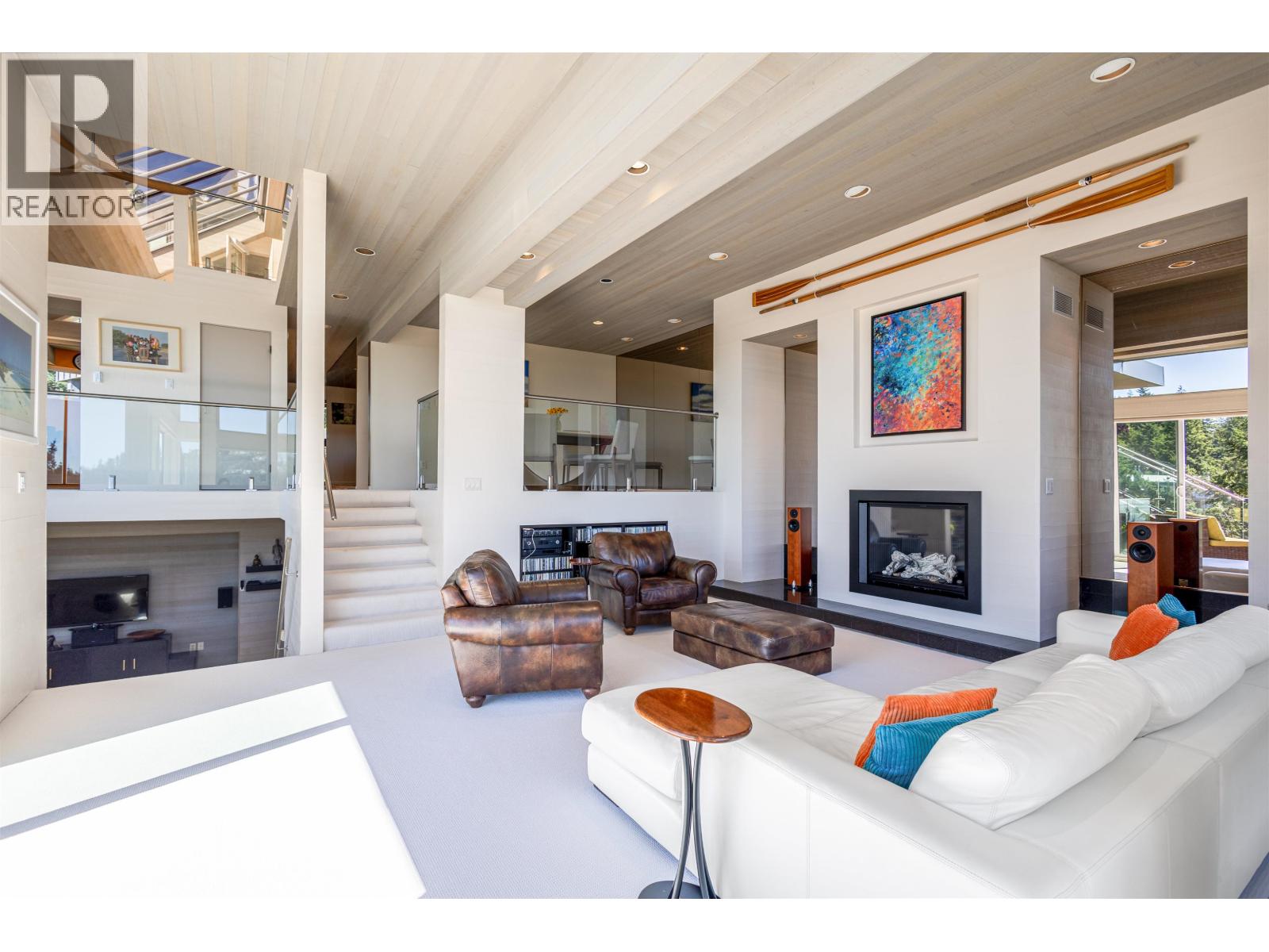A modern living room with a fireplace and a painting on the wall.