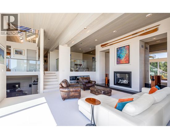 A modern living room with a fireplace and a painting on the wall.