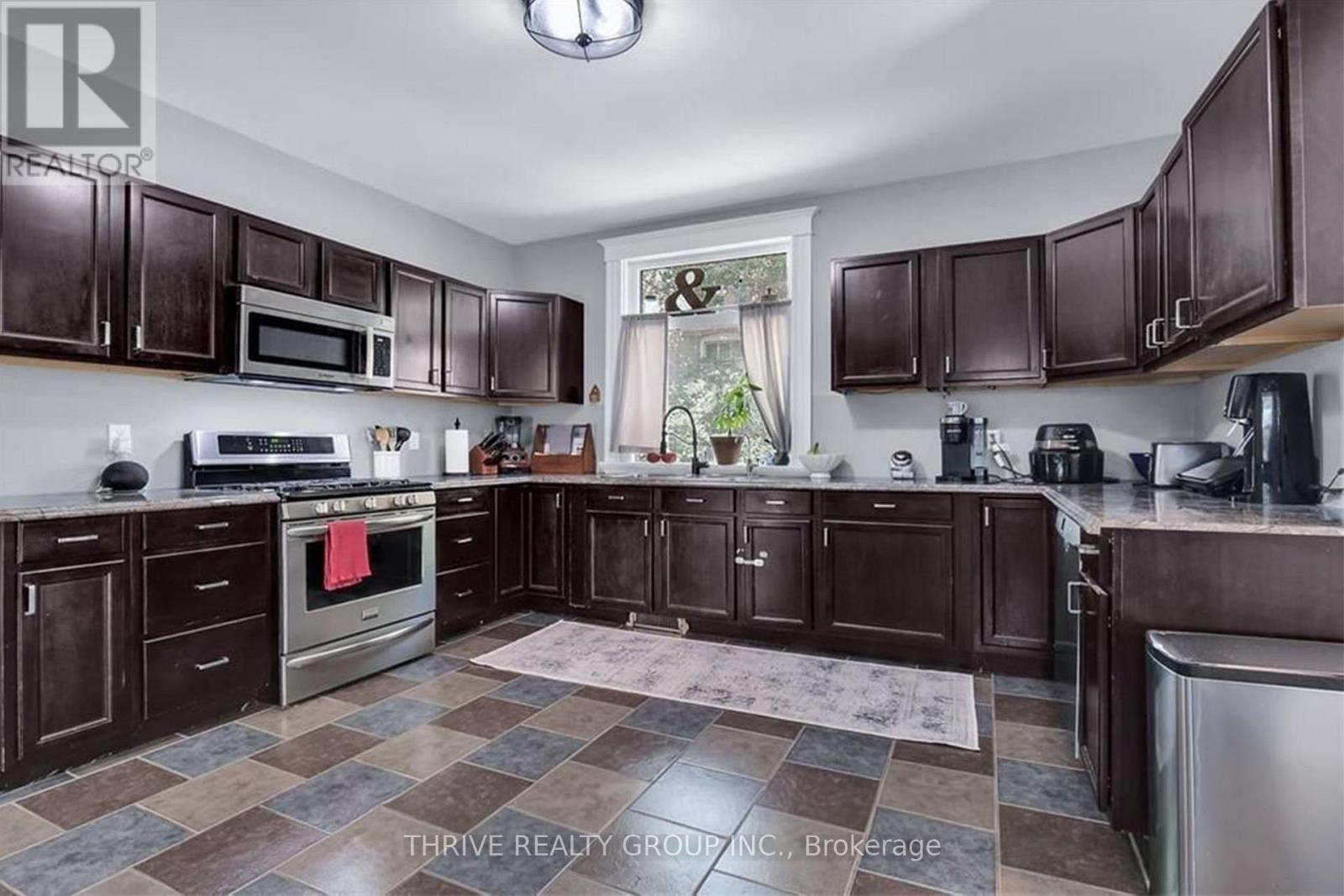 A kitchen with dark brown cabinets and a checkered floor.