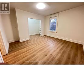 A room with wooden flooring and a window.