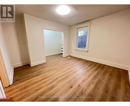 A room with wooden flooring and a window.