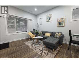 A living room with a grey couch, yellow pillows, and a wooden coffee table.