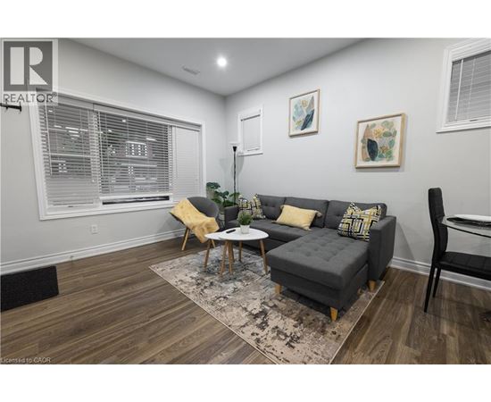 A living room with a grey couch, yellow pillows, and a wooden coffee table.