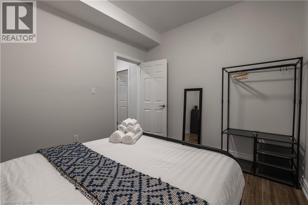 A bedroom with a white bed and a black and white patterned throw.