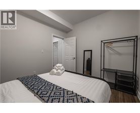 A bedroom with a white bed and a black and white patterned throw.