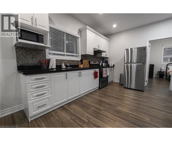 A kitchen with white cabinets and a black countertop.