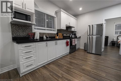 A kitchen with white cabinets and a black countertop.
