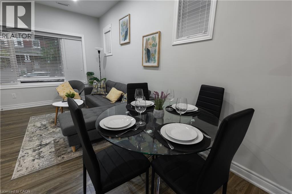A dining room with a glass table and black chairs.