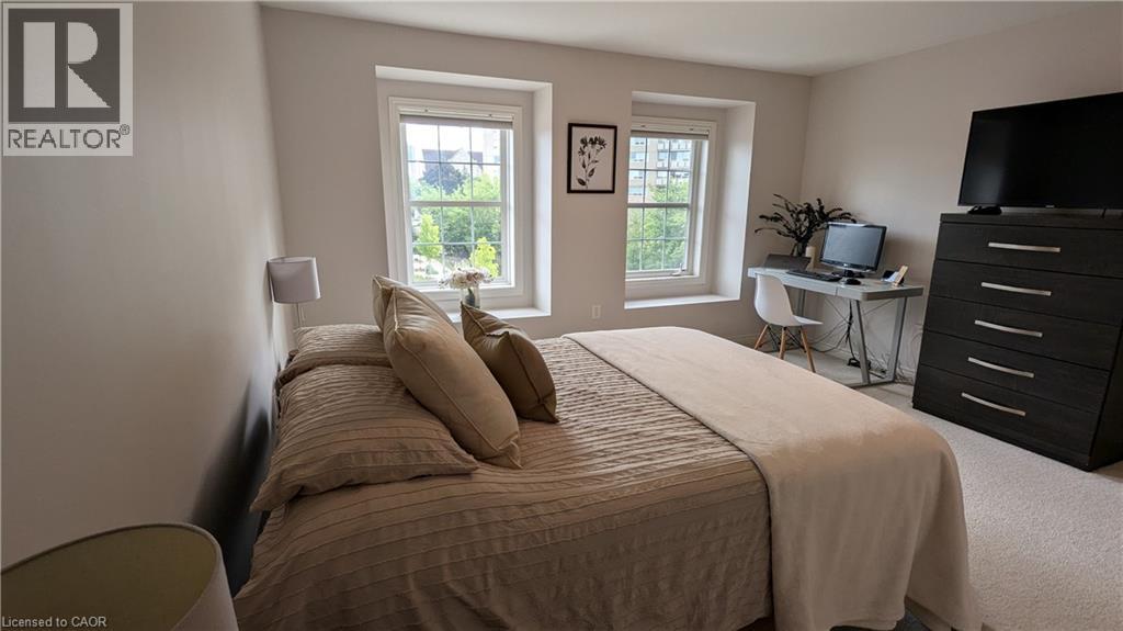 A bedroom with a large bed and a desk with a computer.