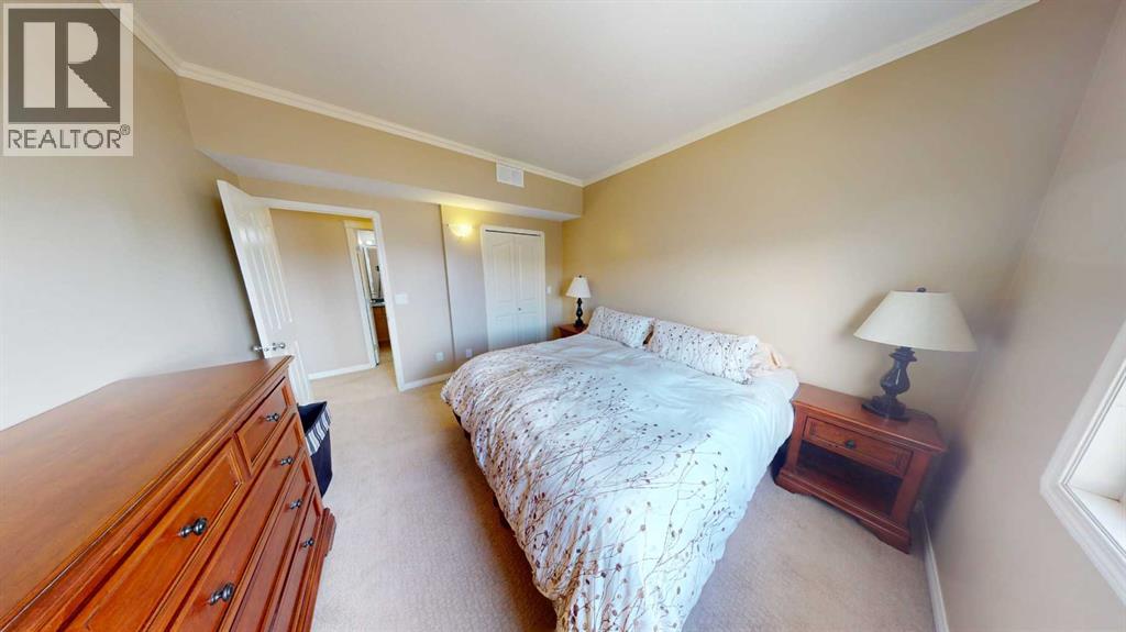 A bedroom with a bed, nightstand, and lamp.
