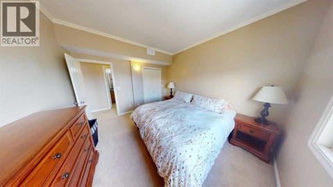 A bedroom with a bed, nightstand, and lamp.