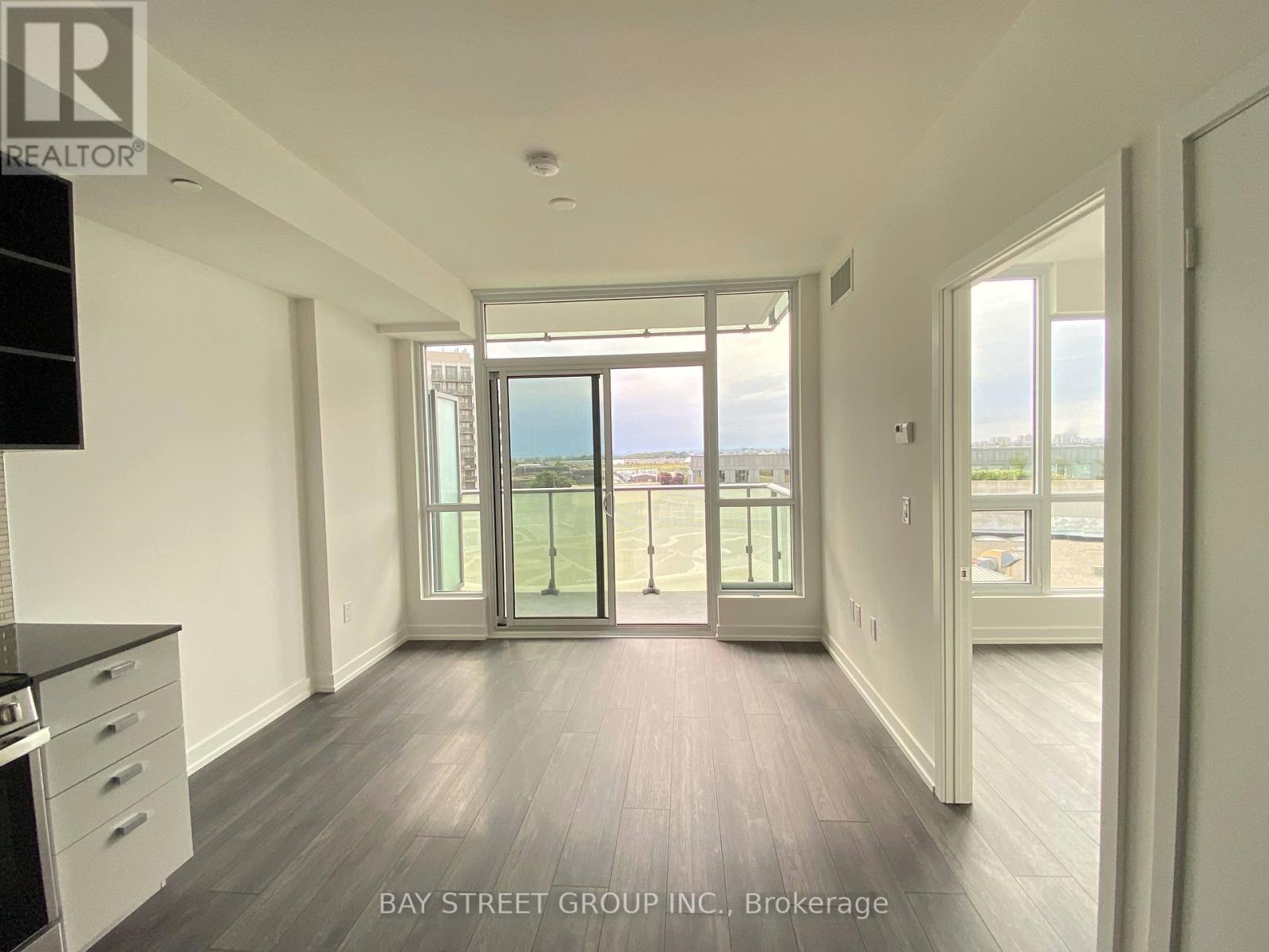 A spacious room with a view of the beach through the sliding glass doors.
