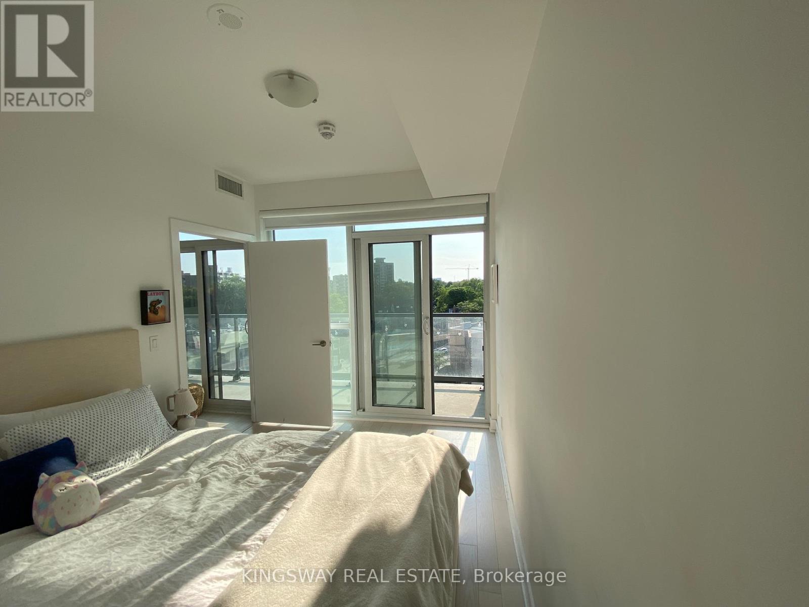 A bedroom with a bed and a window with a view of the city.